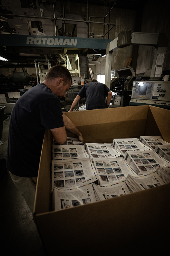 Here you can see stacks of the catalog being placed in bins to head to assembly.