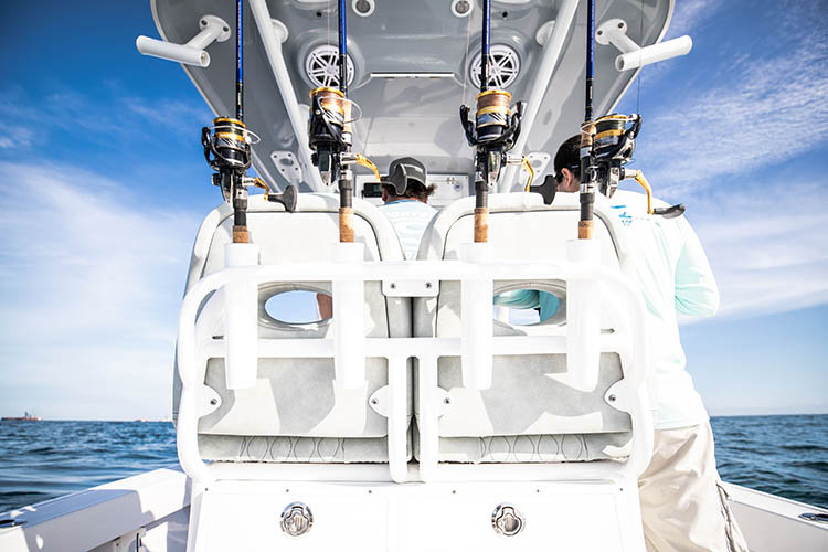 Picture of spinning reels in rod mounts on boat.