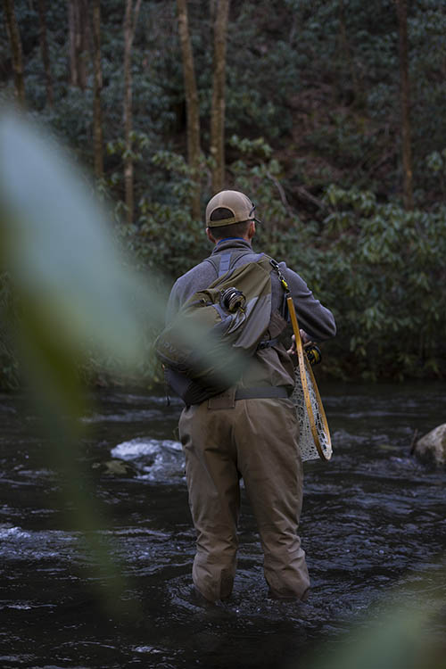 Man in creek fly fishing.