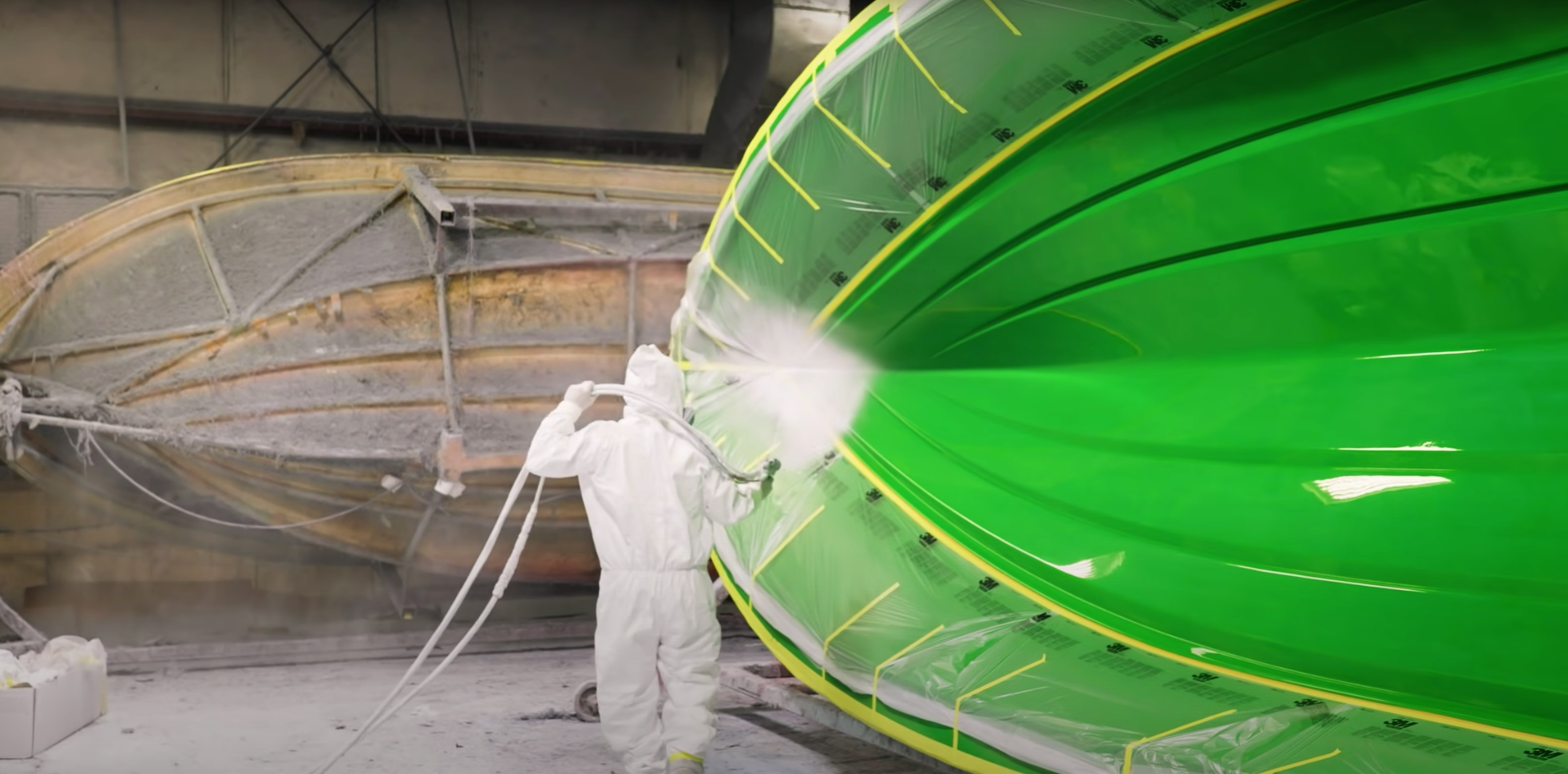 Image of Sportsman Boats employee spraying boat mold with white gelcoat. 