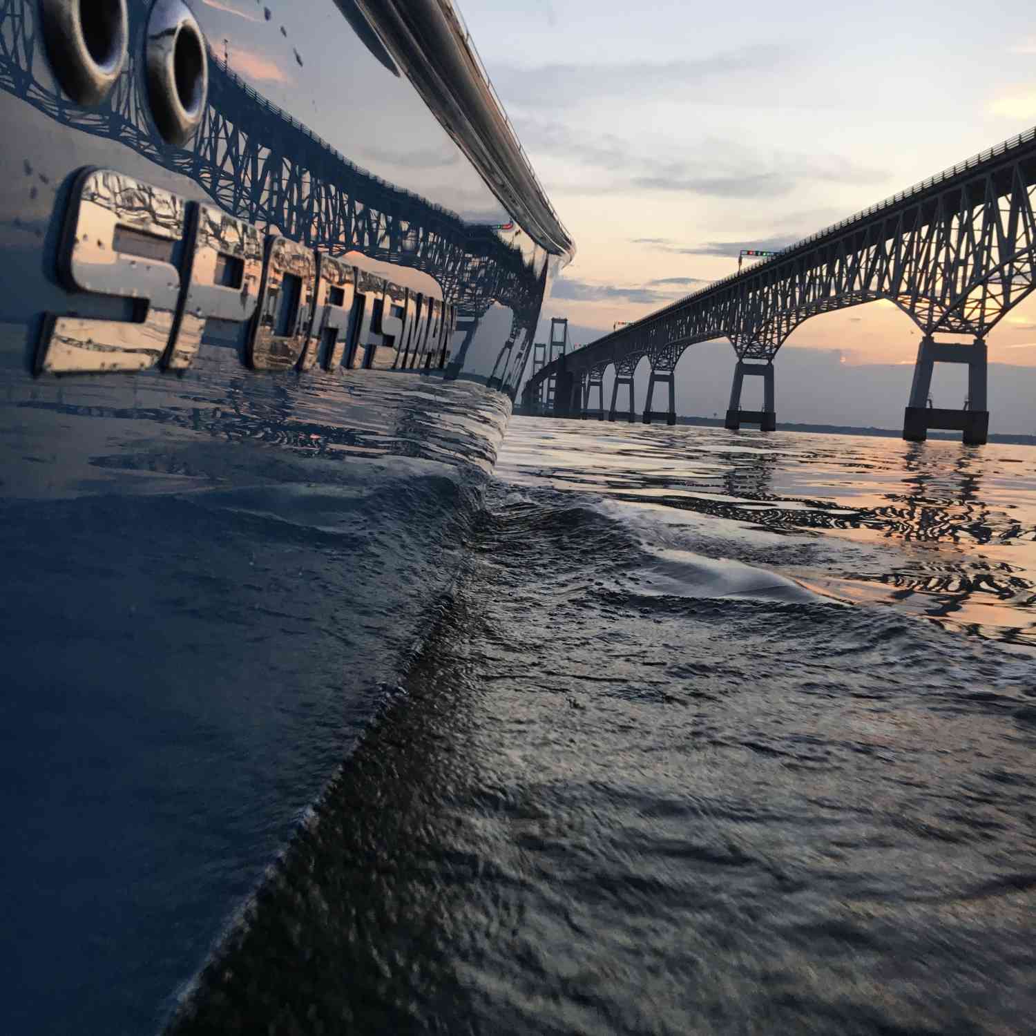 Chesapeake Bay Bridge reflection off an Island Blue 252 open Sportsman with a sunset backdrop