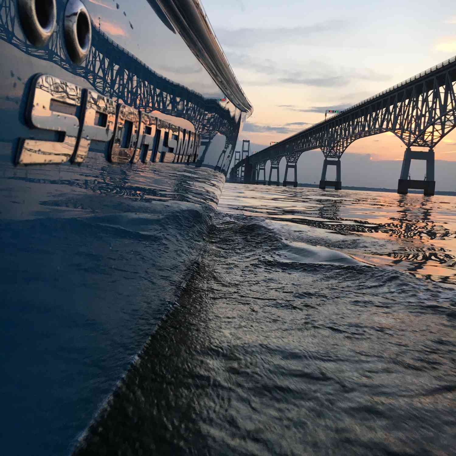 Sportsman logo with a view of the Chesapeake bay bridge and a beautiful sunset