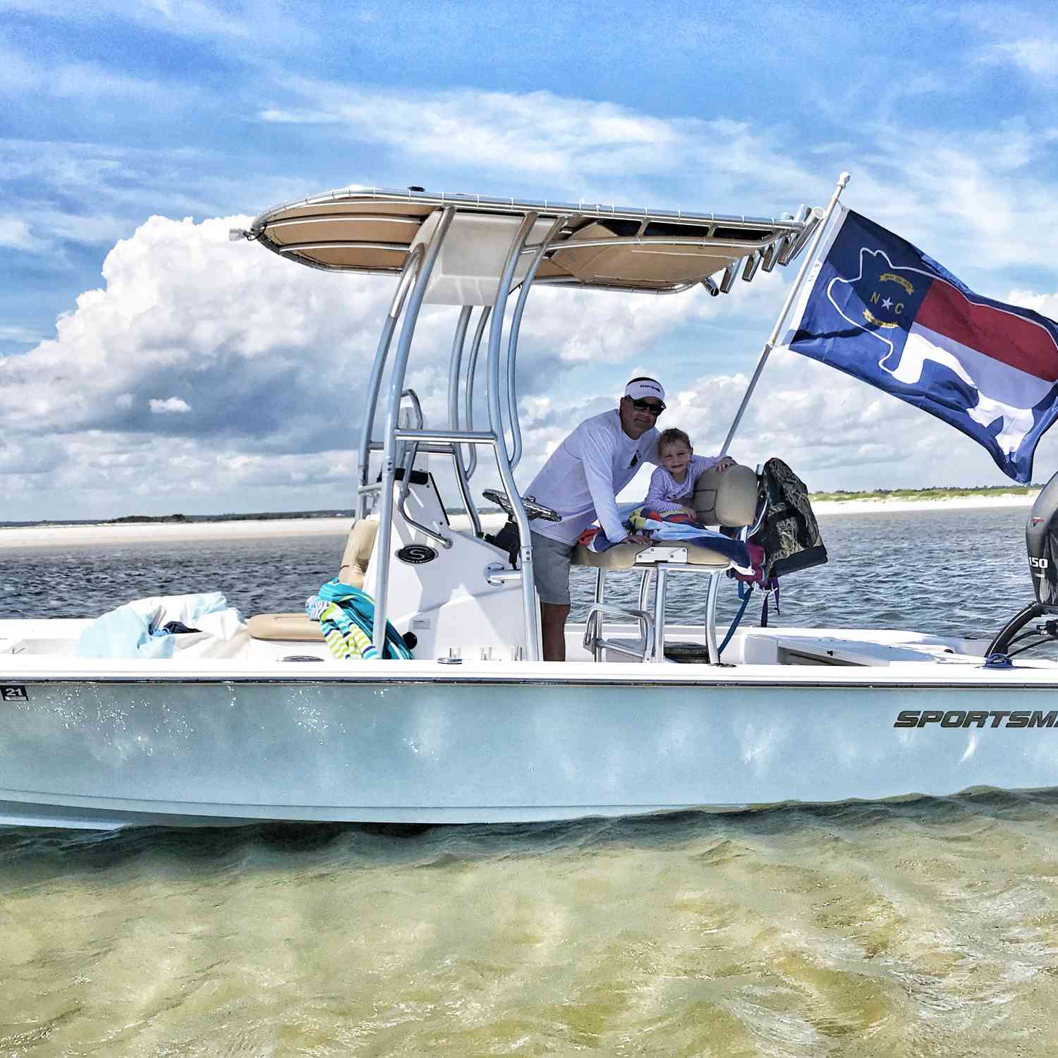 Daddy and Daughter relaxing on Sportsman boat with our NC Pig Flag representing hog farmers on the island.