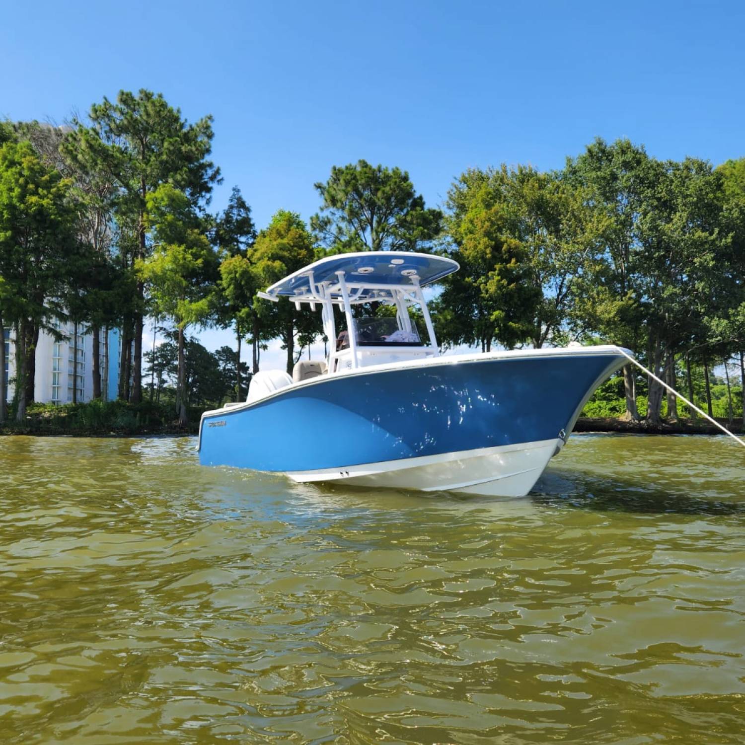 Sportsman Center Console Heritage 241 anchored near Margaritaville resort along the tree line.